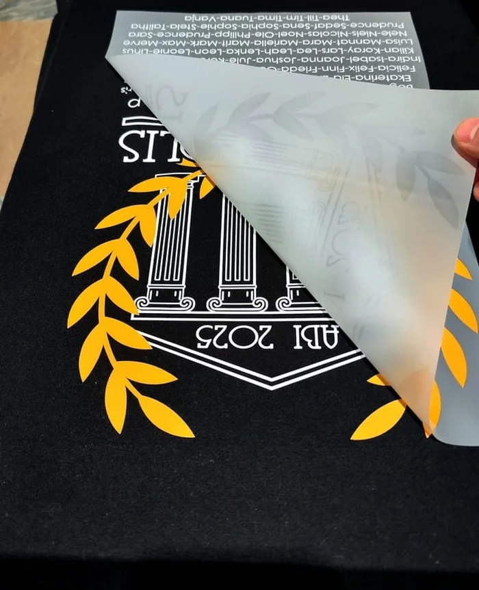 Vinyl-Transferfolie wird von einem bedruckten schwarzen Textil abgezogen